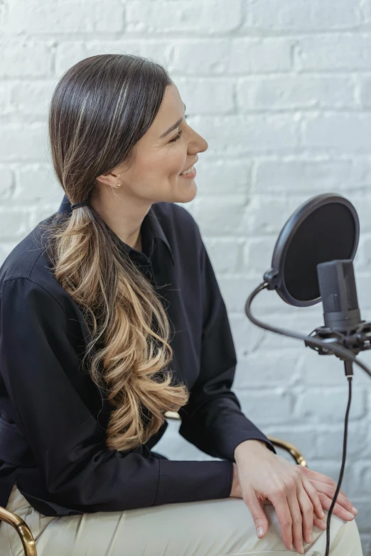 a woman sitting in front of a microphone, long hair with a ponytail, studio quality product, jay bauman, view from the side
