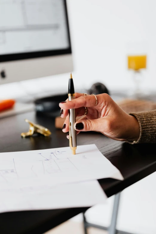 a person sitting at a desk with a pen and paper, curated collections, centered design, uploaded, low quality photo