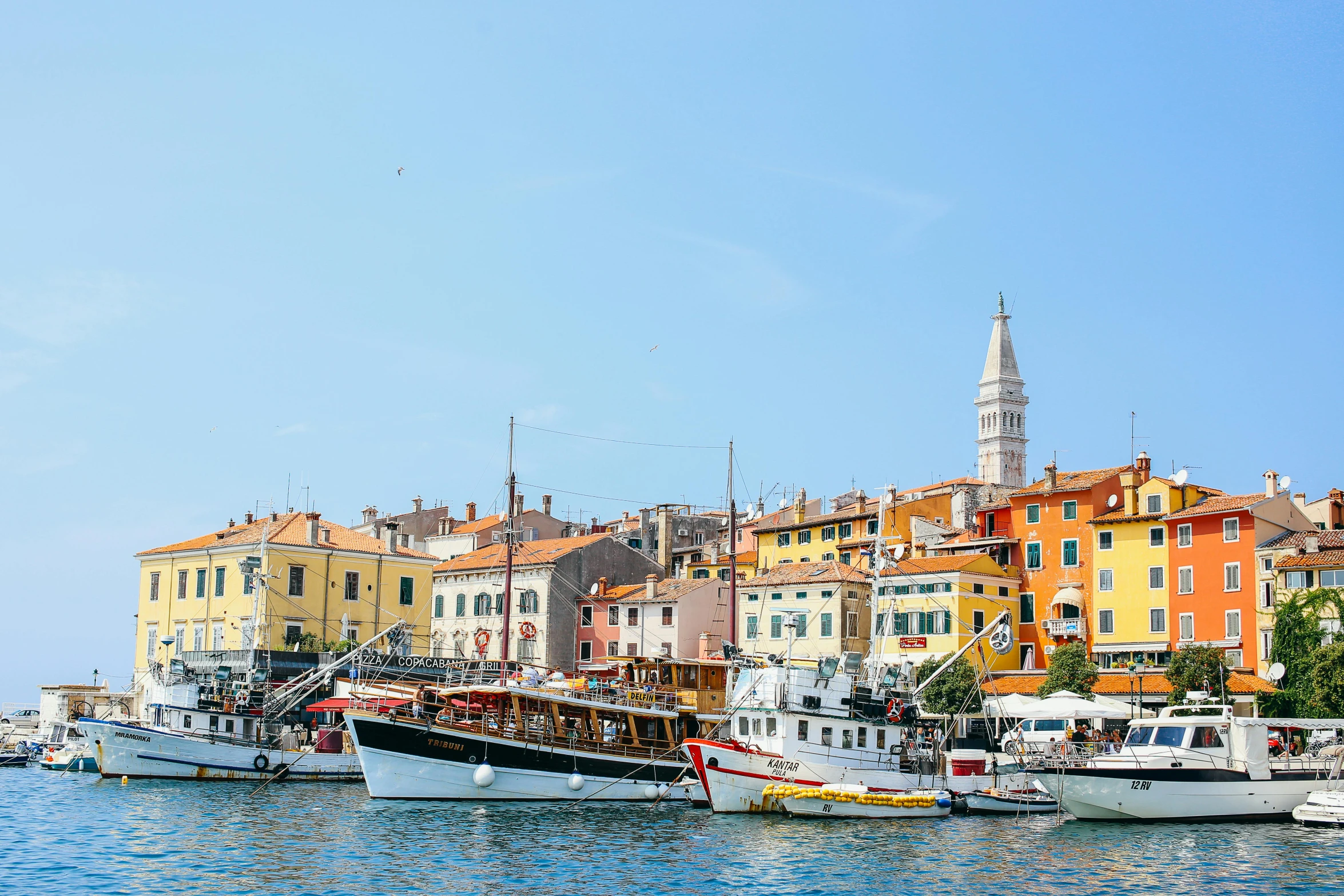 a group of boats floating on top of a body of water, by Tom Wänerstrand, pexels contest winner, croatian coastline, square, in the style wes anderson, city of pristine colors