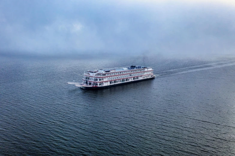 a large boat traveling across a large body of water, by Carey Morris, pexels contest winner, romanticism, memphis, great river, grey mist, holiday season