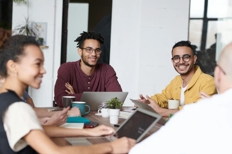 a group of people sitting around a table with laptops, trending on pexels, ethnic group, avatar image, professional image, handsome