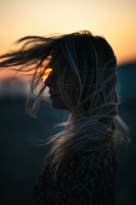 a woman with her hair blowing in the wind, pexels contest winner, sunset glow around head, blonde, ((sunset)), texture