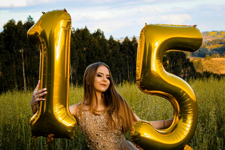 a woman standing in a field holding a golden number 5 balloon, unsplash, 18 years old, attractive photo, detailed letters, 15081959 21121991 01012000 4k