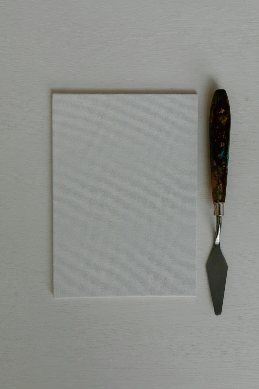 a knife sitting on top of a piece of paper, a minimalist painting, inspired by Kyffin Williams, visual art, white foam, thumbnail, art station cfg _ scale 9, rectangle