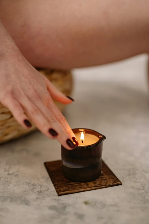 a close up of a person holding a candle, brown, manicured, playful vibe, square