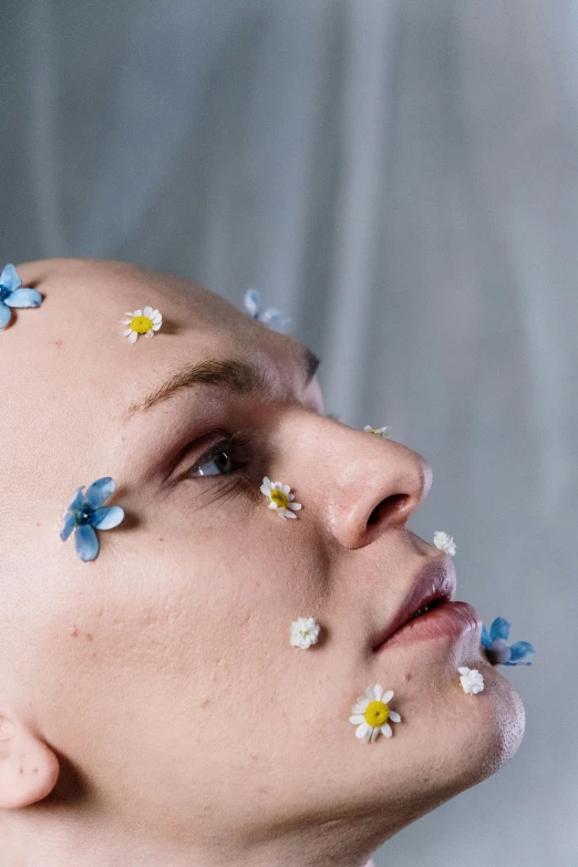 a man with flowers all over his face, an album cover, inspired by Elsa Bleda, trending on pexels, aestheticism, shaved face, eleven/millie bobbie brown, detailed face of an android, close - up studio photo