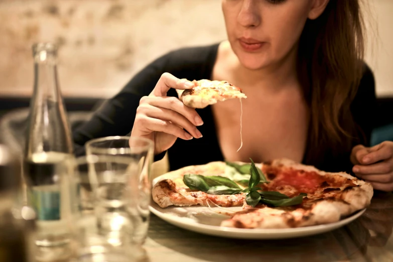 a woman eating a slice of pizza at a restaurant, by Niko Henrichon, pexels contest winner, renaissance, gooey skin, side fed, 15081959 21121991 01012000 4k, petite