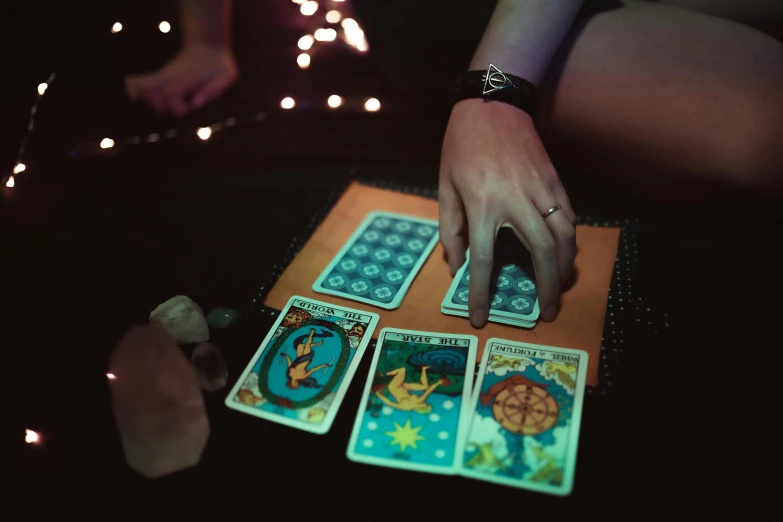 a close up of a person holding a deck of cards, by Julia Pishtar, pexels contest winner, renaissance, wizard doing a tarot reading, floating symbols and crystals, nighttime, rectangle