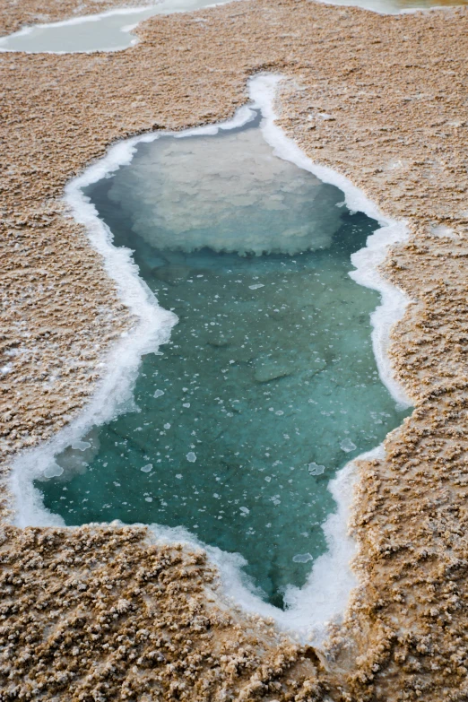 a pool of water in the middle of a desert, trending on unsplash, land art, frozen and covered in ice, honey, tungsten, humid ground