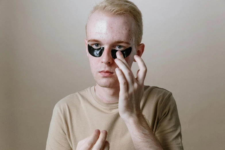 a man with a pair of eye patches on his face, trending on pexels, albino white pale skin, hands on face, vantablack, lean man with light tan skin