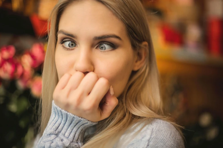 a woman holding her hand to her mouth, a picture, trending on pexels, happening, mysterious coffee shop girl, worm mouth, dry skin, surprised