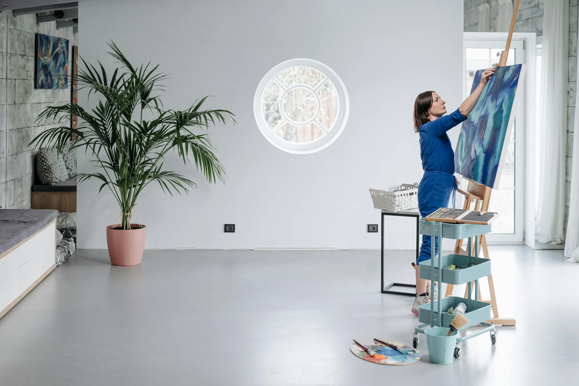 a woman that is standing in front of a painting, white wall coloured workshop, painting on the ceiling, illustration », blue planet still