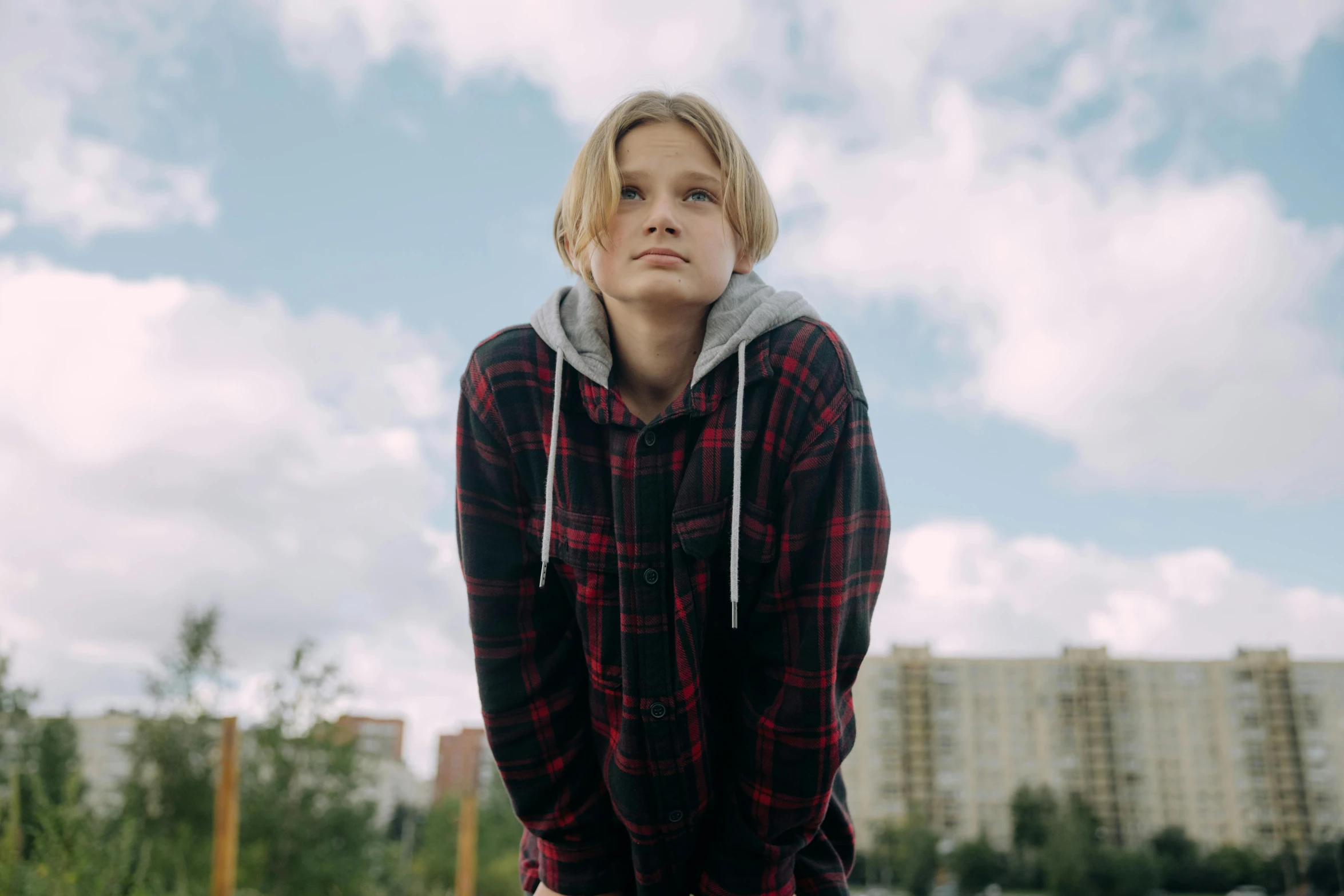 a woman sitting on top of a skateboard, by Emma Andijewska, trending on pexels, hyperrealism, blond boy, tartan hoodie, human staring blankly ahead, pictured from the shoulders up