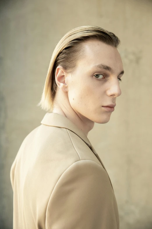 a close up of a person wearing a jacket, inspired by Carlo Mense, trending on pexels, bauhaus, long swept back blond hair, jamie campbell bower, lean sleek styling, artem chebokha