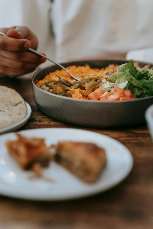 a person sitting at a table with plates of food, pexels contest winner, hurufiyya, bowl, middle eastern skin, mac and cheese, digital image