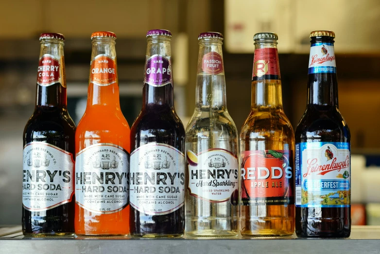 a row of beer bottles sitting on top of a counter, inspired by Henry Bright, hurufiyya, reds, multicoloured, hr ginger, thumbnail