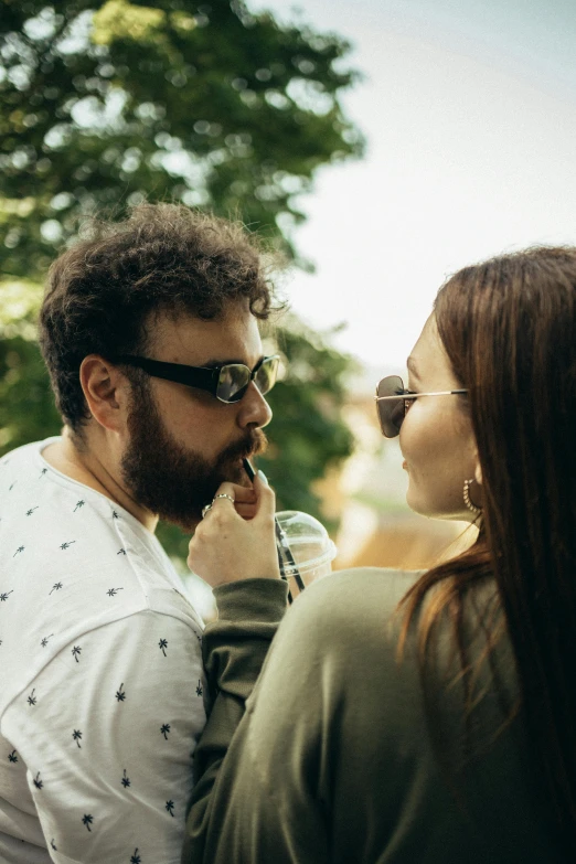 a man and a woman standing next to each other, by Adam Marczyński, pexels contest winner, renaissance, eating outside, with glasses and goatee, making out, shady look