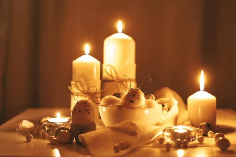 a group of candles sitting on top of a table, a still life, pexels, translucent eggs, warm yellow lights, cosy, festive