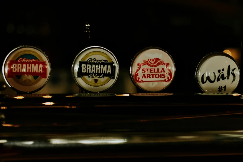 a row of beer taps sitting on top of a bar, a still life, by Bertram Brooker, unsplash, process art, straya, four arms, beer logo, round-cropped