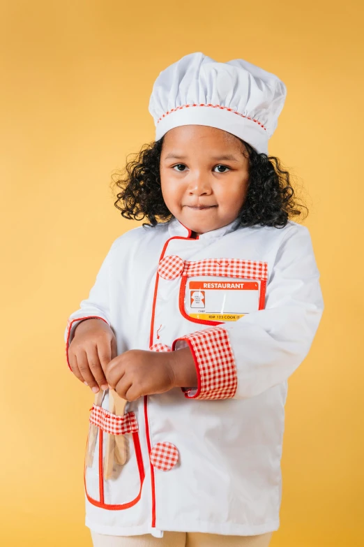 a little girl wearing a chef's hat and holding a spatula, inspired by Norman Rockwell, shutterstock contest winner, colorful uniforms, diverse costumes, 2019 trending photo, kids toys