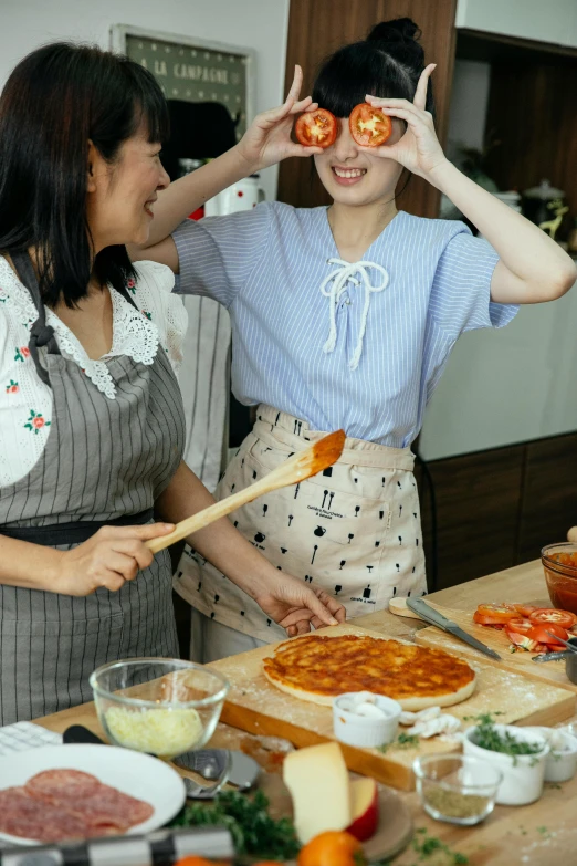 a couple of women standing next to each other in a kitchen, pexels contest winner, renaissance, cooking pizza, korean, promo image, caramel