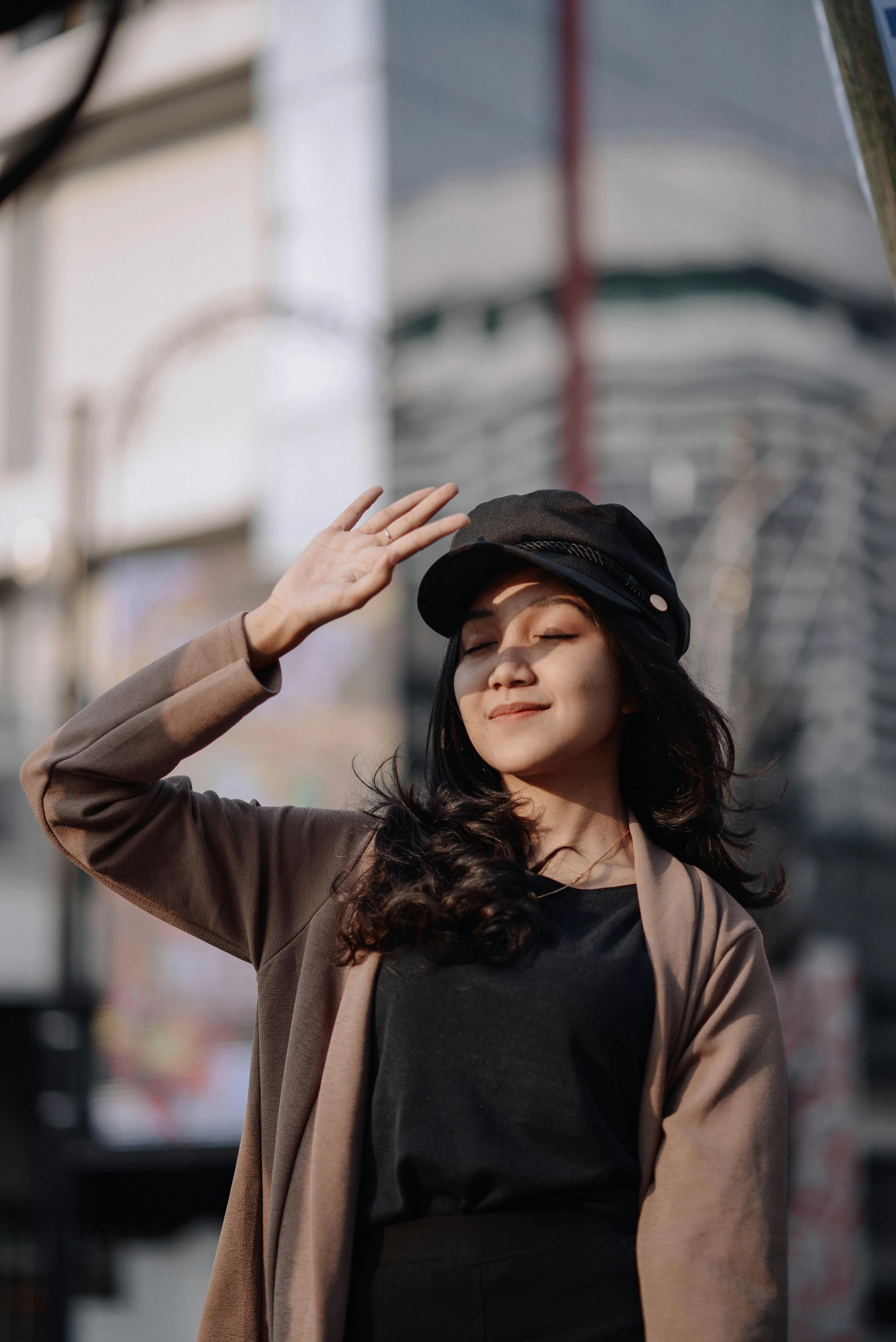 a woman standing in front of a street sign, pexels contest winner, caracter with brown hat, greeting hand on head, portrait of modern darna, casual black clothing