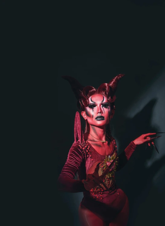 a woman dressed as a devil in a dark room, an album cover, inspired by Ignacy Witkiewicz, trending on pexels, transgressive art, ru paul\'s drag race, javanese mythology, profile image, square