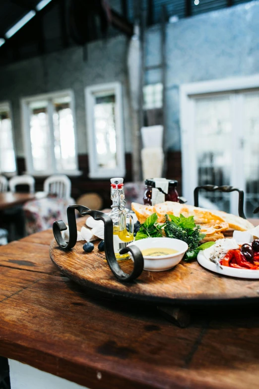 a wooden table topped with plates of food, renaissance, rustic setting, bright natural light, market setting, greek setting