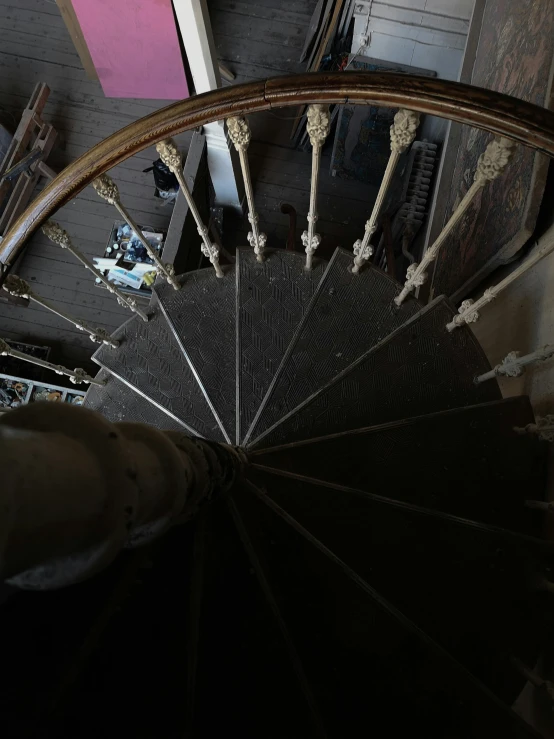 a view from the top of a spiral staircase, photo of poor condition, behind the scenes, promo image, in a dusty victorian home