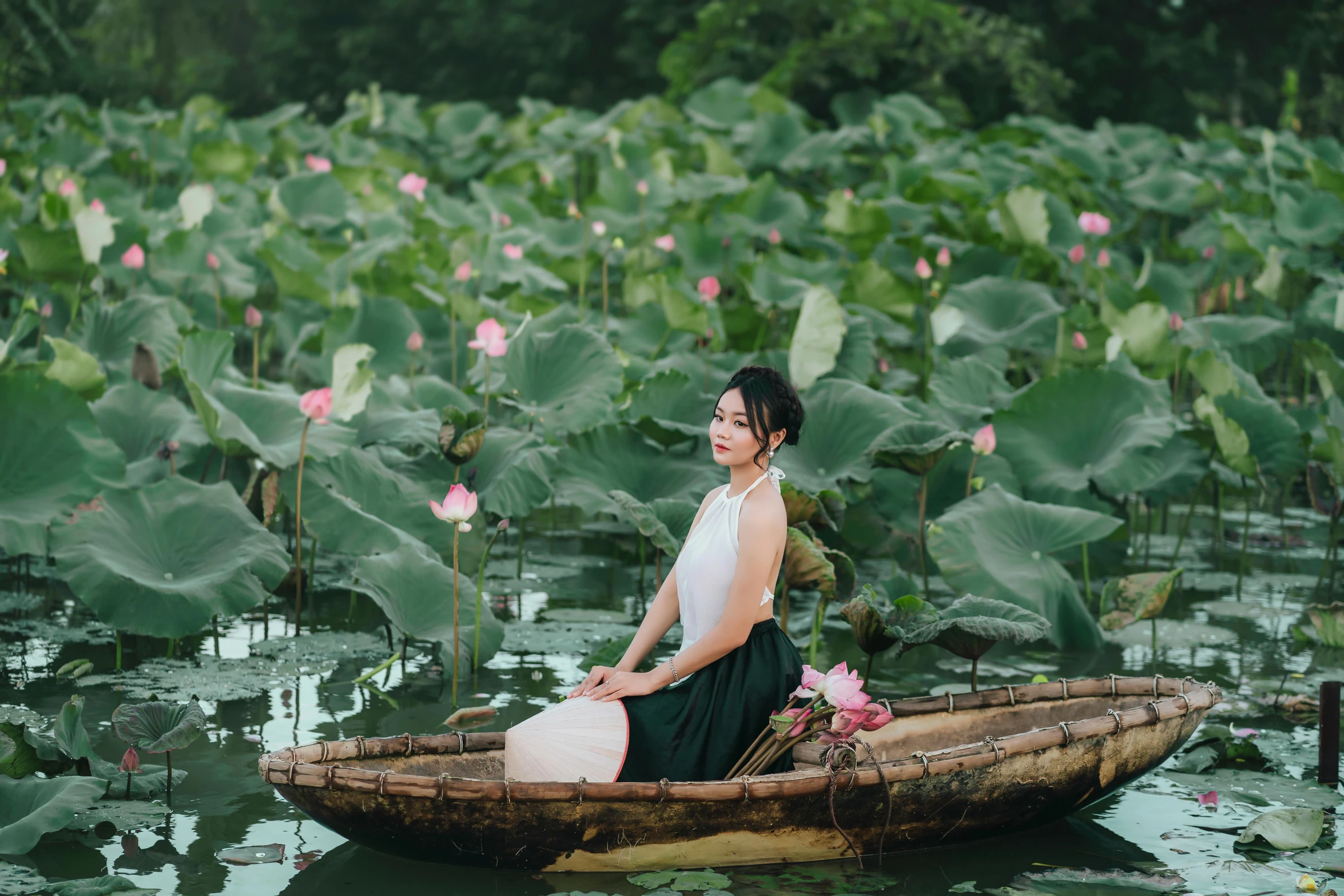 a woman sitting on top of a boat in a body of water, by Shang Xi, pexels contest winner, lotuses, avatar image, photoshoot for skincare brand, half image