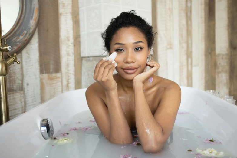 a beautiful young woman sitting in a bath tub, a portrait, pexels, putting makeup on, mixed-race woman, float, iris compiet