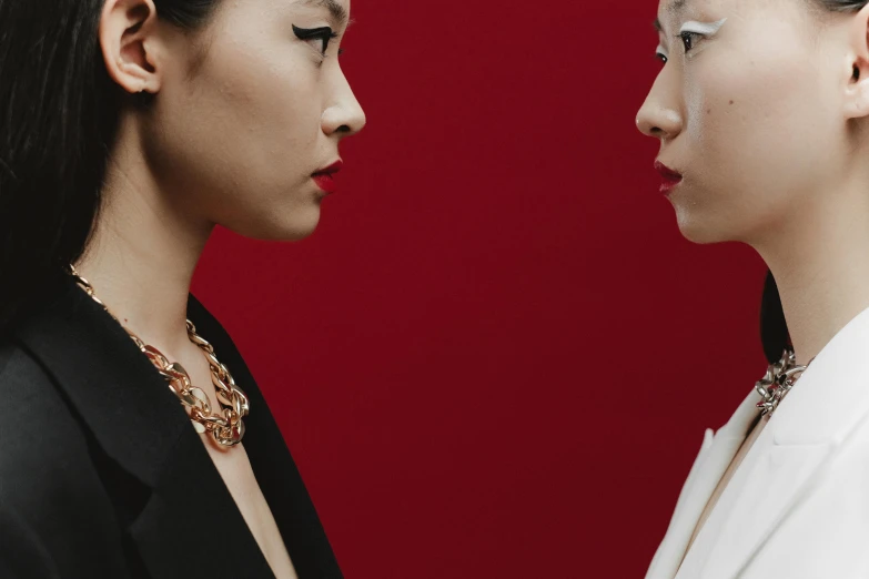 a couple of women standing next to each other, an album cover, inspired by Wang Duo, trending on pexels, hyperrealism, red jewelry, facing each other, ethnicity : japanese, van cleef & arpels