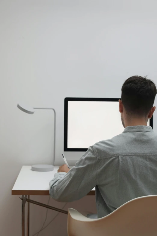 a man sitting at a desk in front of a computer, a computer rendering, pexels, sitting in an empty white room, ignant, screen light, white tracing