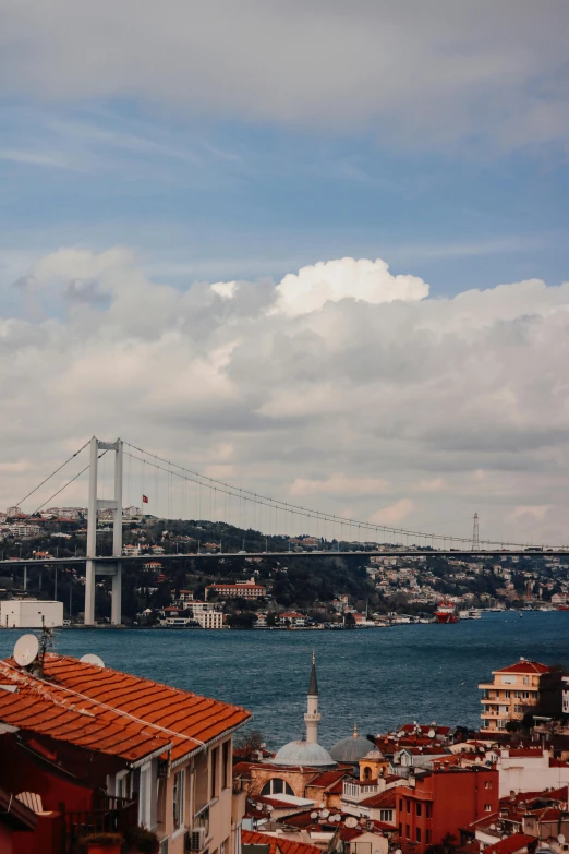 a view of a city with a bridge in the background, a colorized photo, pexels contest winner, hurufiyya, view of sea, taken with kodak portra, mixture turkish and russian, square