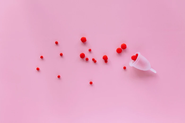 a bunch of red berries sitting on top of a pink surface, by Julia Pishtar, trending on pexels, plasticien, spilled milk, detailed glowing red implants, speculum, membrane pregnancy sac