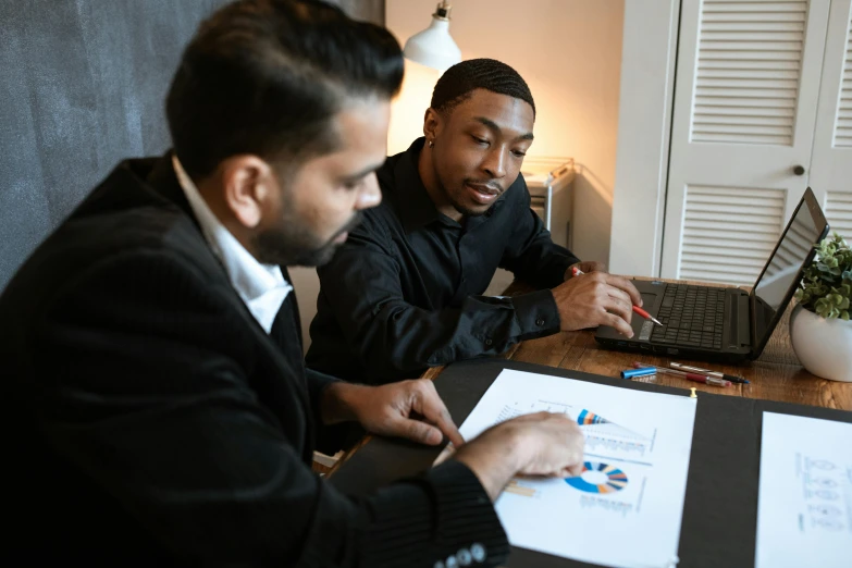 two men sitting at a table working on laptops, pexels contest winner, charts, riyahd cassiem, looking across the shoulder, 1 4 9 3