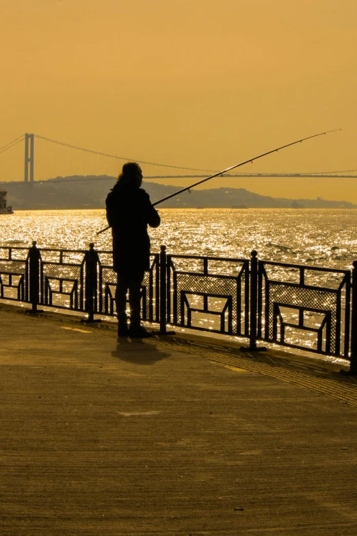 a person standing on a pier with a fishing rod, istanbul, vallejo, photograph of san francisco, photograph