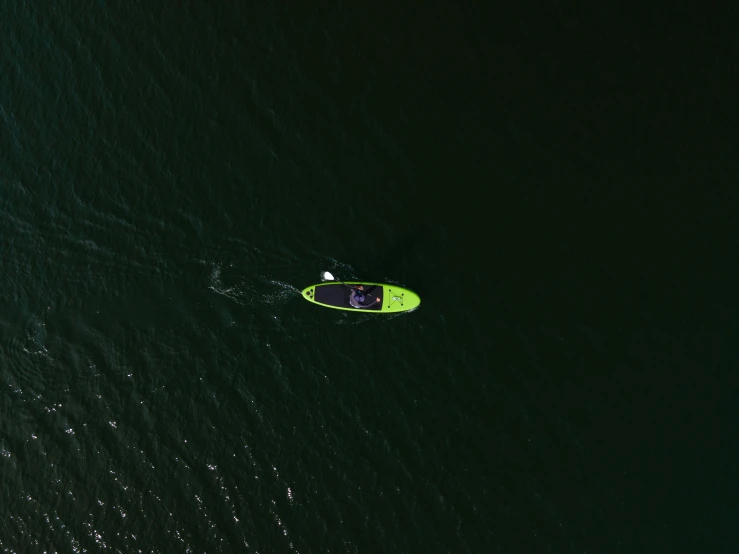 a person riding a surfboard on top of a body of water, a picture, green and black colors, aerial footage, rowing boat, thumbnail