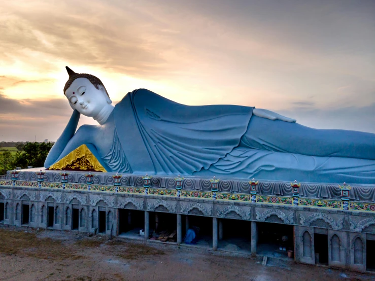 a large statue of a person laying on a platform, pexels contest winner, huge futuristic temple city, myanmar, “hyper realistic, big long cloth on the wind