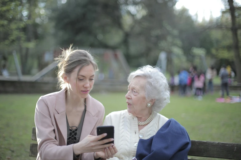 two women sitting on a bench looking at a cell phone, pexels contest winner, an old lady, 15081959 21121991 01012000 4k, teenage girl, looking her shoulder