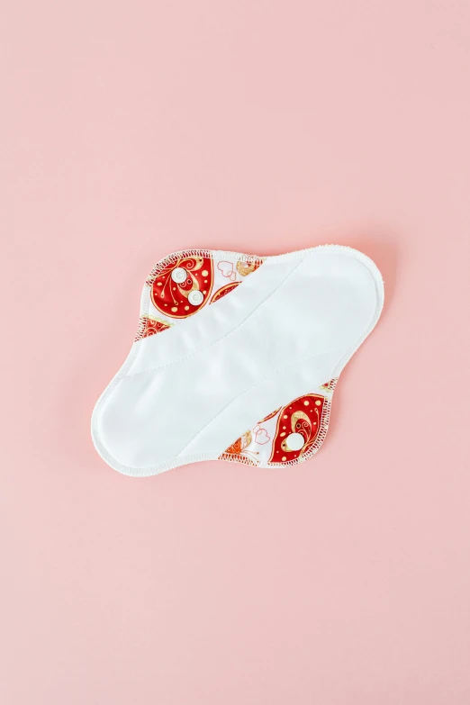 a pair of slippers sitting on top of a pink surface, white and orange breastplate, soft pads, red and white color theme, cervix awakening