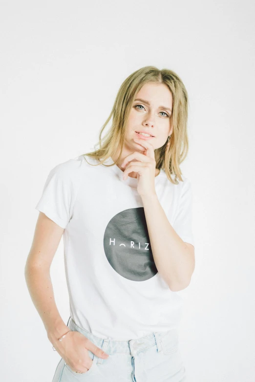 a woman posing for a picture with her hand on her chin, inspired by Harriet Zeitlin, tumblr, minimalism, t-shirt, rounded logo, white moon in the background, hi - rez