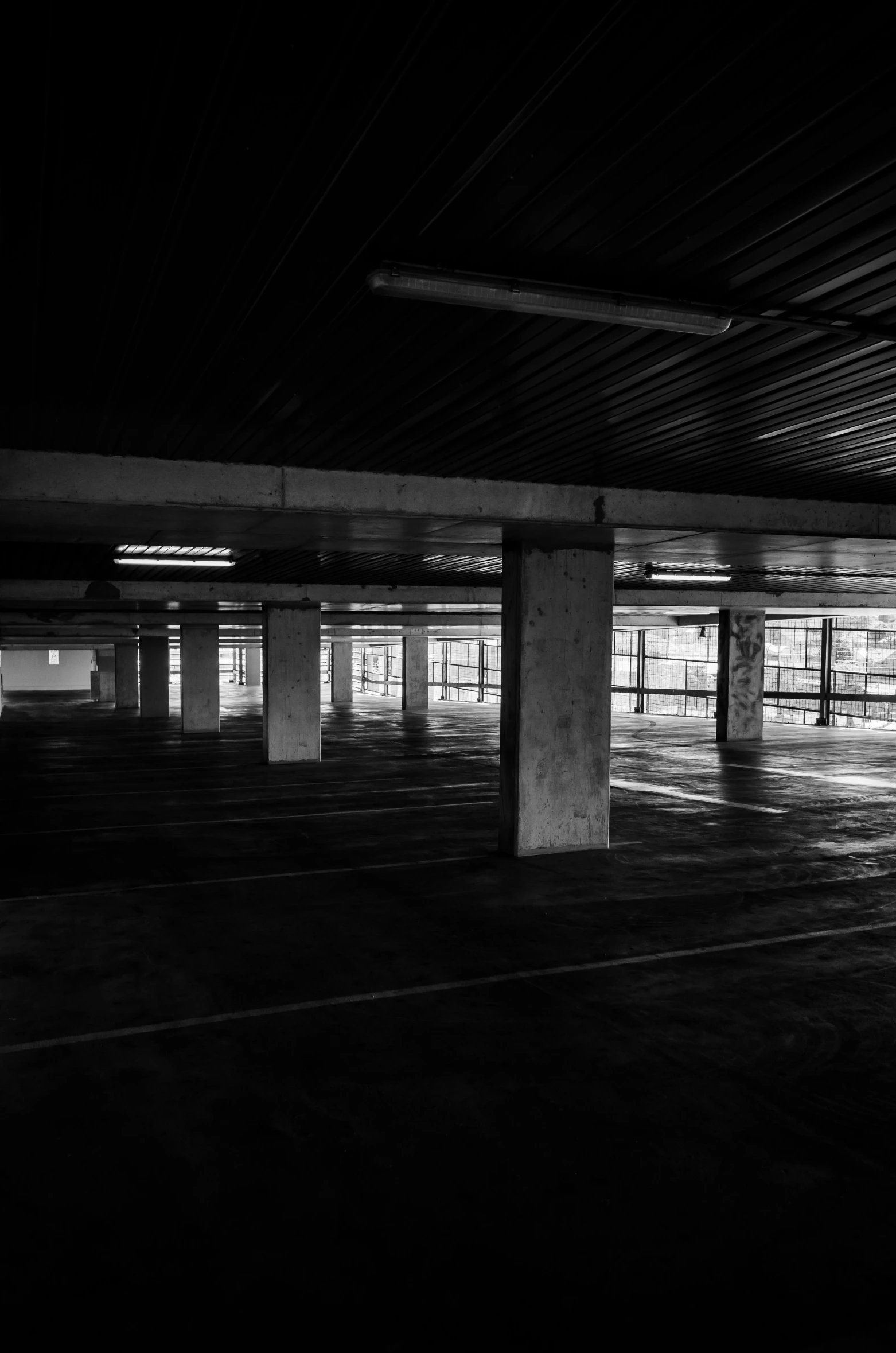 a black and white photo of an empty parking garage, by Altichiero, square, underexposed, cinematic shot ar 9:16 -n 6 -g, urbex