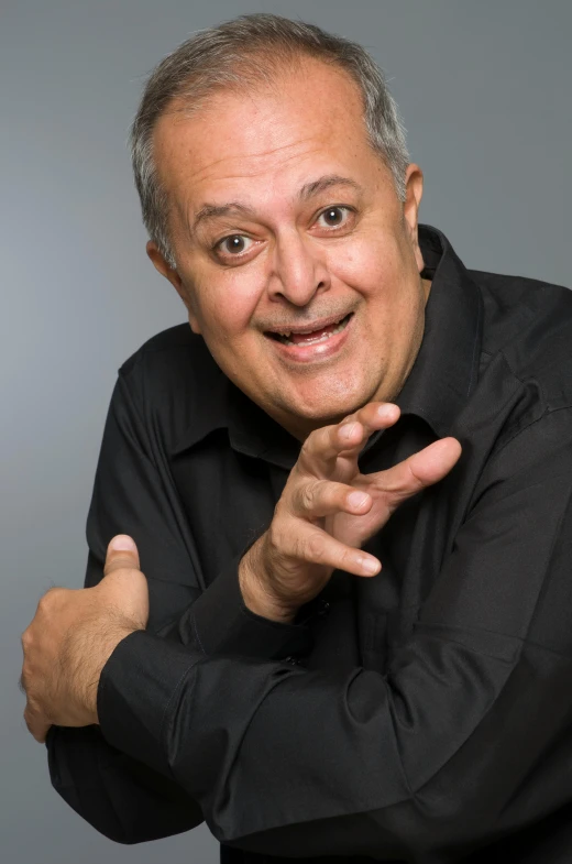 a man in a black shirt posing for a picture, inspired by Francis Souza, bending down slightly, frank reynolds, press shot, mahmud barzanji