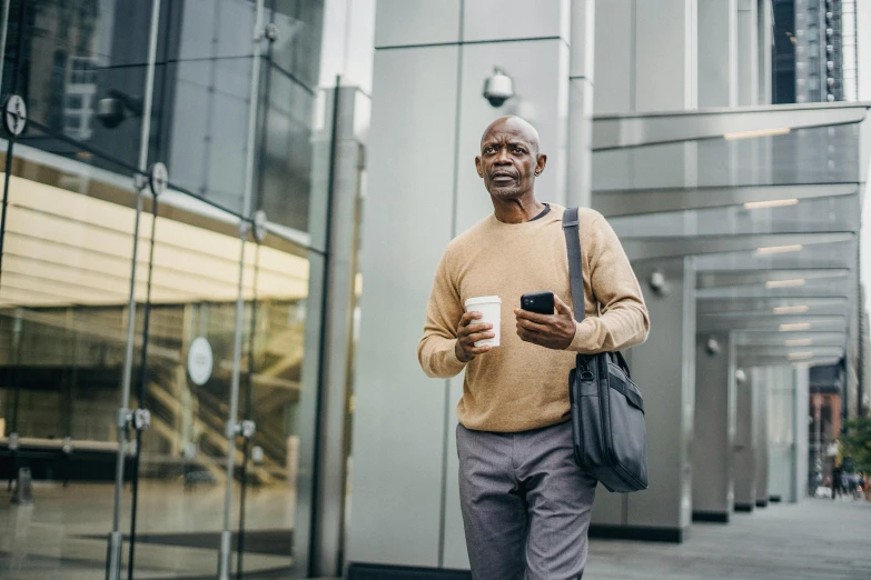 a man walking down the street holding a cup of coffee, digital health, black. airports, older male, thumbnail