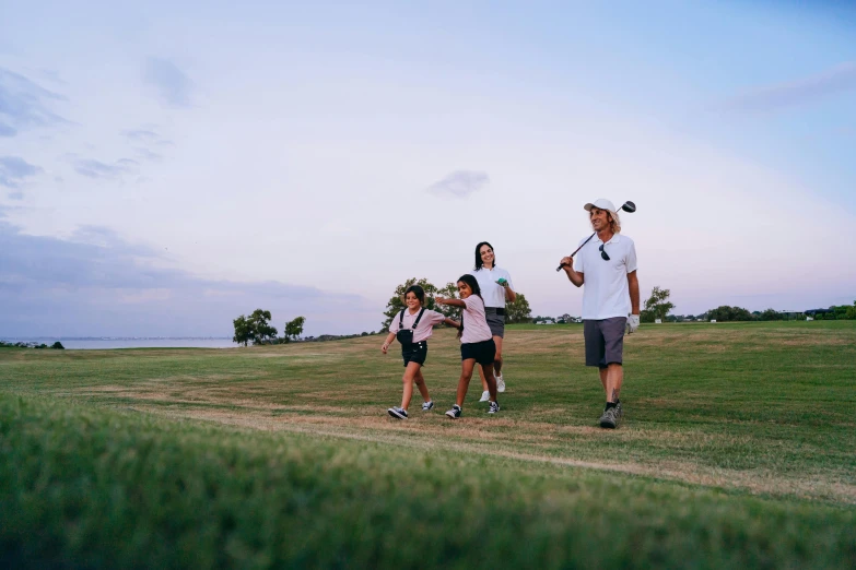 a group of people standing on top of a lush green field, in the evening, wrx golf, walking at the park, profile image