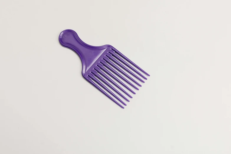 a purple comb sitting on top of a white table, ((purple)), multi - coloured, short spout, african