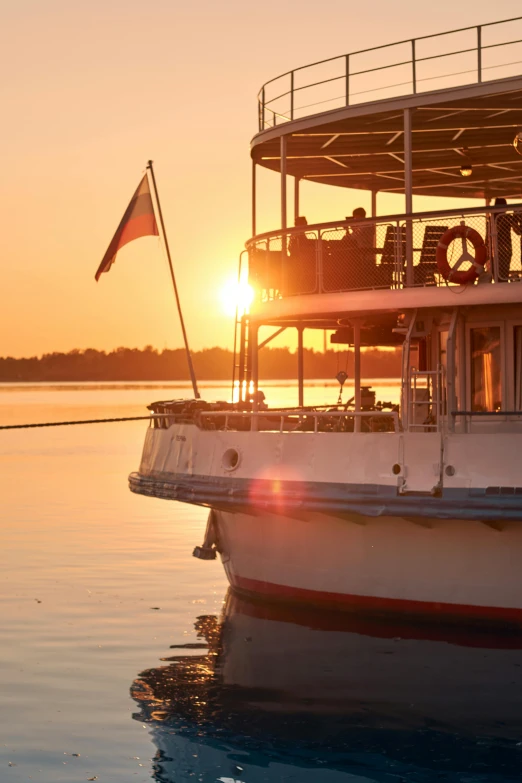 a large boat sitting on top of a body of water, the golden hour, at the golden hour, palatial scene