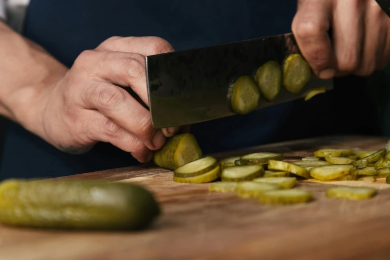 a person cutting up pickles on a cutting board, unsplash, photorealism, subtle detailing, plating, ilustration, close up image