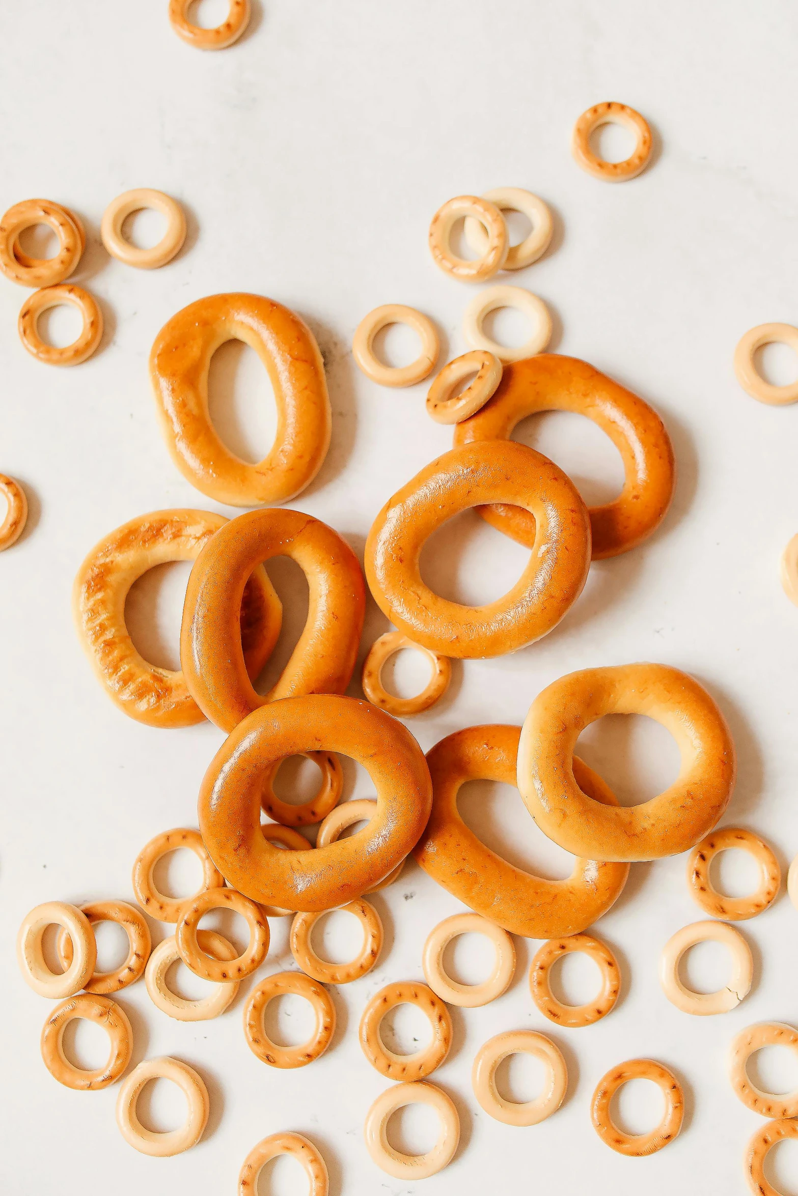 a pile of pretzels sitting on top of a table, orbital rings, natural soft rim light, various sizes, opaque